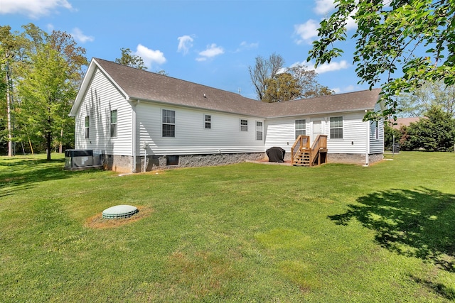 back of house with cooling unit and a yard