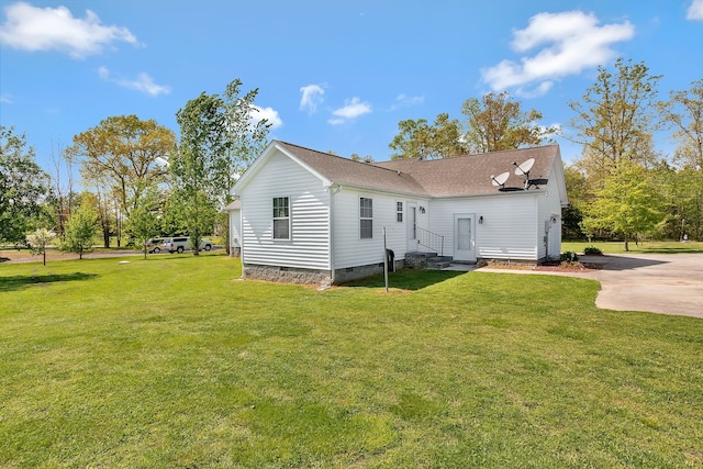 rear view of property featuring a lawn