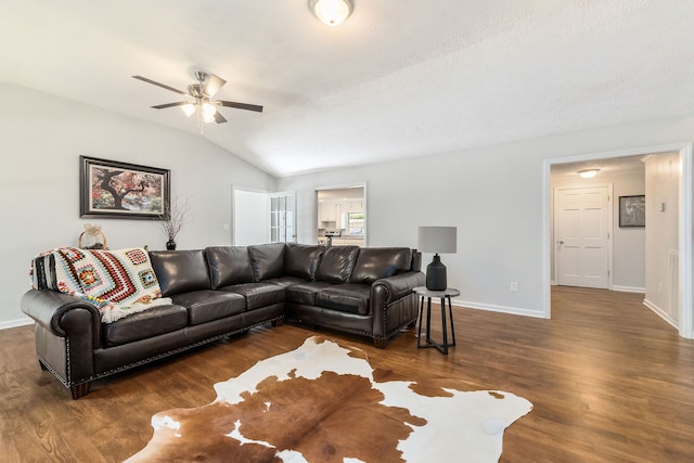 living room featuring dark wood-type flooring, ceiling fan, and vaulted ceiling