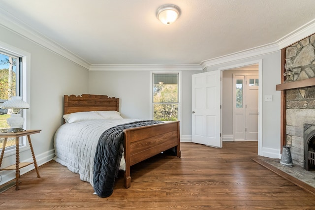 bedroom featuring ornamental molding, a fireplace, and dark hardwood / wood-style floors