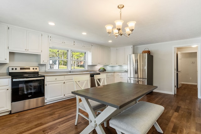 kitchen with hanging light fixtures, white cabinetry, dark hardwood / wood-style floors, a notable chandelier, and stainless steel appliances