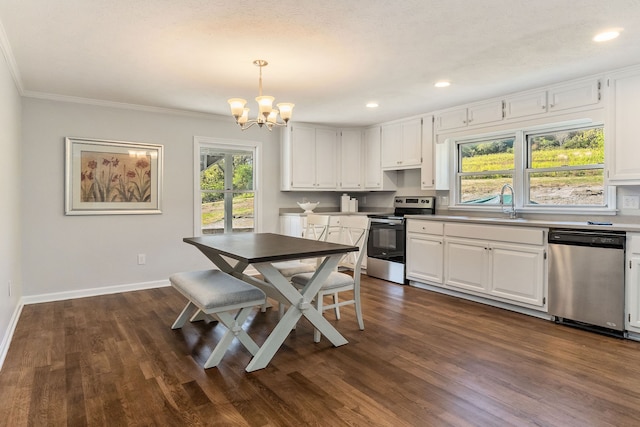 kitchen featuring dark hardwood / wood-style floors, appliances with stainless steel finishes, pendant lighting, and white cabinets