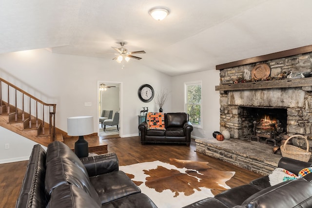 living room featuring ceiling fan, a stone fireplace, vaulted ceiling, and dark hardwood / wood-style floors