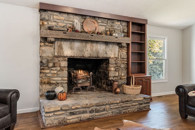 interior space featuring a textured ceiling, a fireplace, and dark hardwood / wood-style flooring