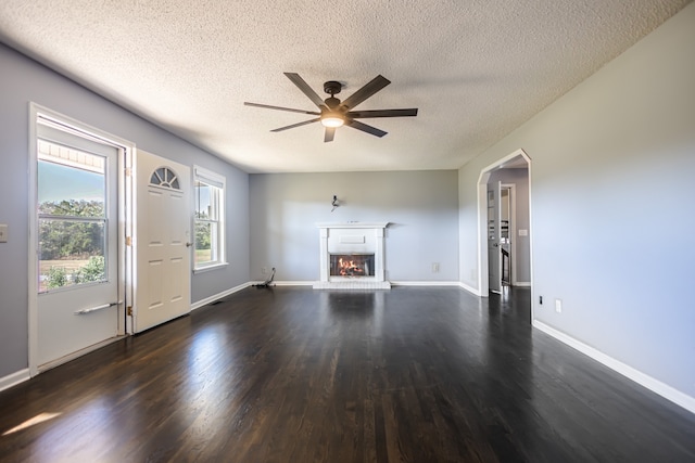 unfurnished living room with dark hardwood / wood-style floors, a textured ceiling, and ceiling fan