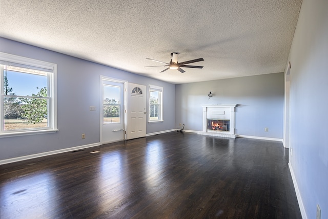 unfurnished living room featuring ceiling fan, a textured ceiling, and dark hardwood / wood-style floors