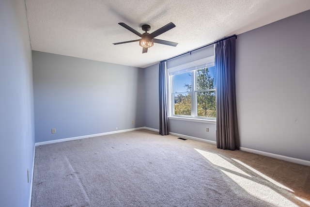 unfurnished room featuring ceiling fan, light carpet, and a textured ceiling