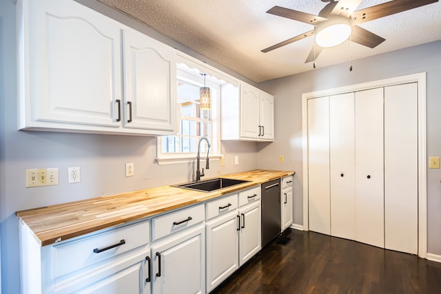 kitchen with wood counters, white cabinets, and sink