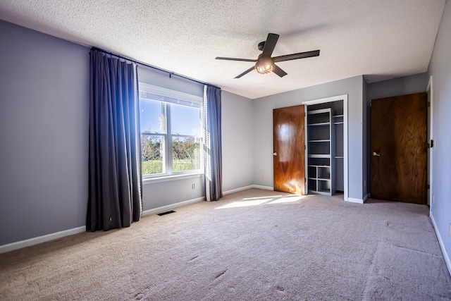 spare room featuring ceiling fan, a textured ceiling, and light colored carpet