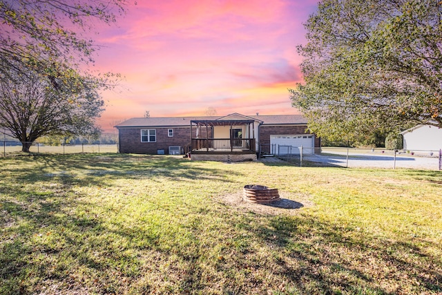 view of front of home featuring a wooden deck, a garage, and a lawn