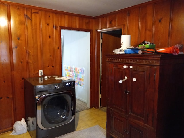 clothes washing area featuring washer / clothes dryer and wooden walls