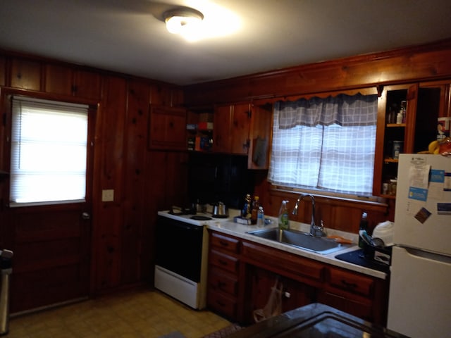 kitchen featuring wood walls, sink, and white appliances