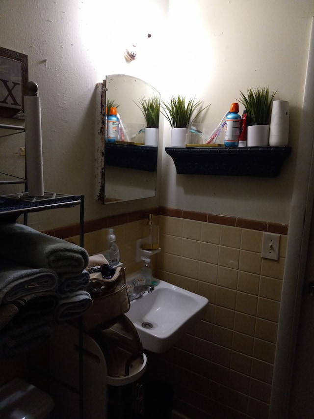 bathroom with tile walls and sink