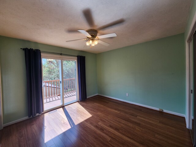 empty room with ceiling fan, dark hardwood / wood-style flooring, and a textured ceiling