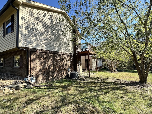 view of home's exterior featuring a deck, a yard, and central AC