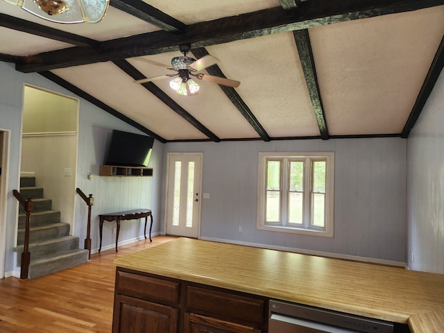 interior space with ceiling fan, dark brown cabinets, lofted ceiling with beams, and light wood-type flooring