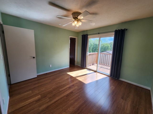 spare room featuring a textured ceiling, ceiling fan, and dark wood-type flooring