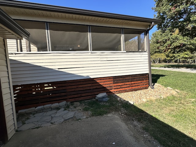 view of property exterior featuring a yard and a sunroom