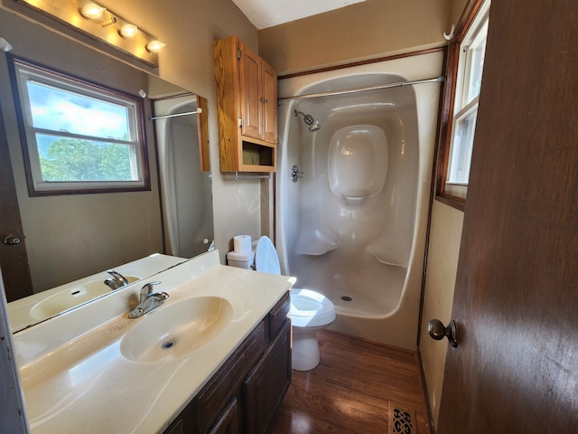 bathroom with toilet, vanity, wood-type flooring, and walk in shower