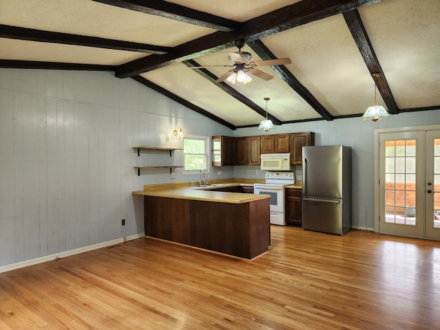 kitchen with kitchen peninsula, decorative light fixtures, white appliances, and vaulted ceiling with beams