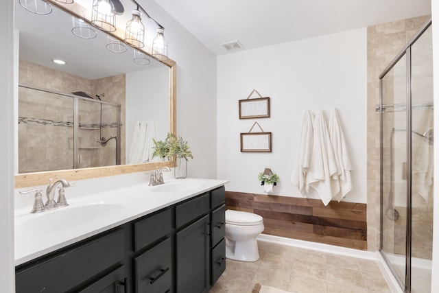 bathroom featuring vanity, toilet, tile patterned flooring, and a shower with door