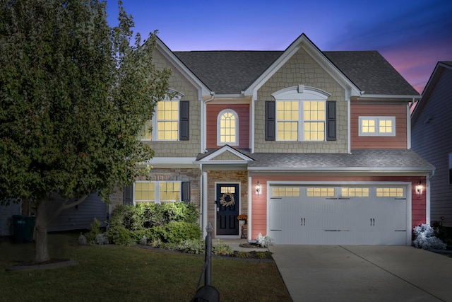 view of front of property featuring a yard and a garage