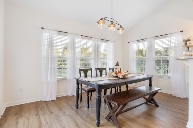 dining area featuring light hardwood / wood-style flooring and high vaulted ceiling