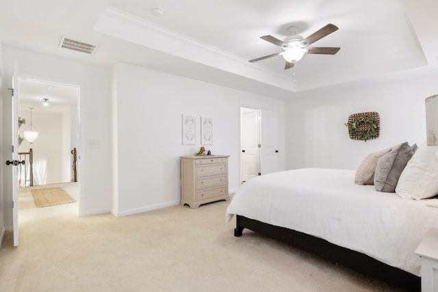 bedroom with ornamental molding, light carpet, ceiling fan, and a raised ceiling