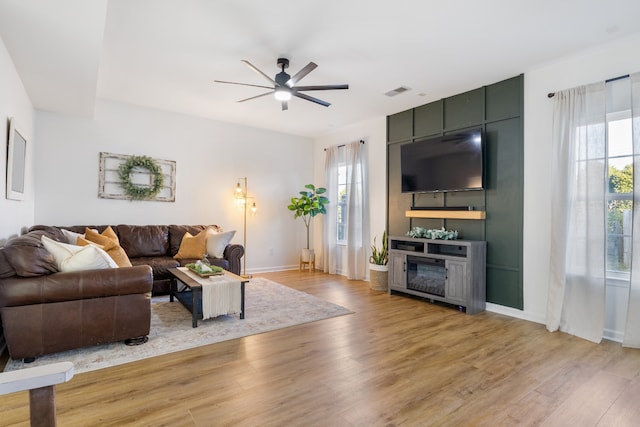 living room with light hardwood / wood-style flooring and ceiling fan