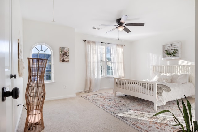 bedroom with ceiling fan, light carpet, and multiple windows