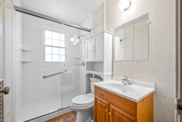 bathroom with toilet, tile walls, walk in shower, vanity, and tile patterned flooring