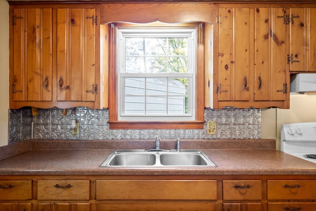 kitchen featuring extractor fan, tasteful backsplash, sink, and white range