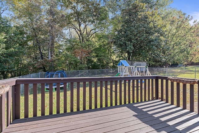 wooden terrace with a playground and a yard