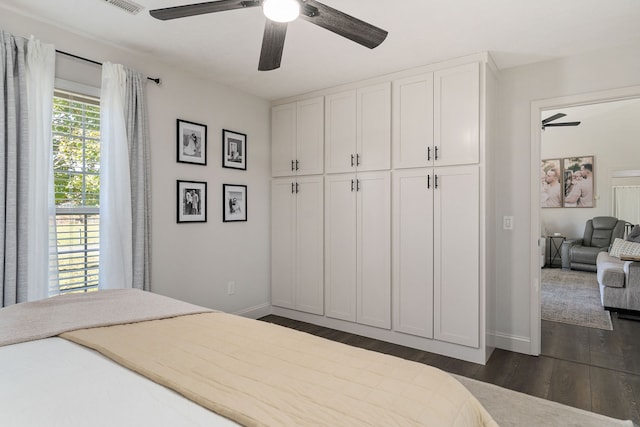 bedroom with dark hardwood / wood-style flooring, a closet, and ceiling fan