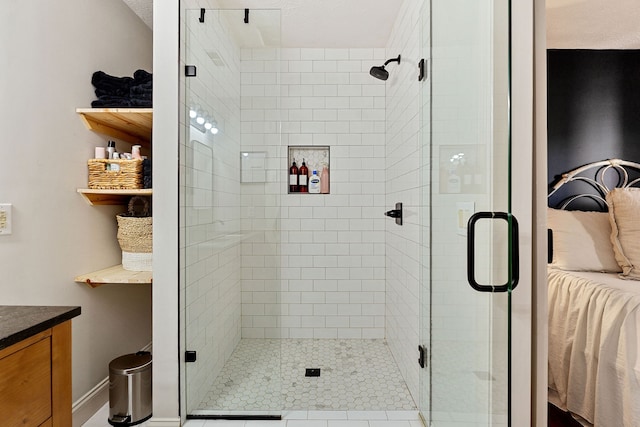 bathroom featuring a shower with door, vanity, and tile patterned floors