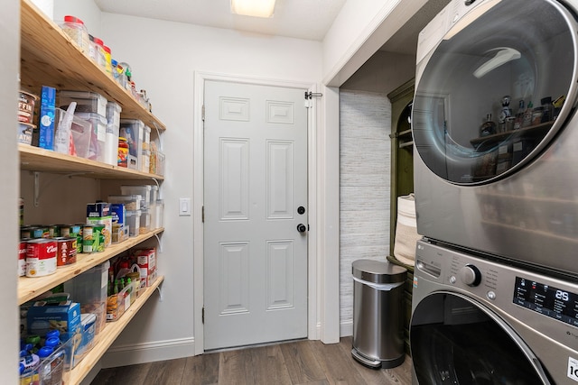 clothes washing area featuring dark wood-type flooring and stacked washer / drying machine