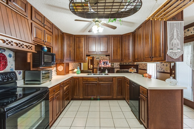 kitchen with kitchen peninsula, sink, black appliances, light tile patterned floors, and a textured ceiling