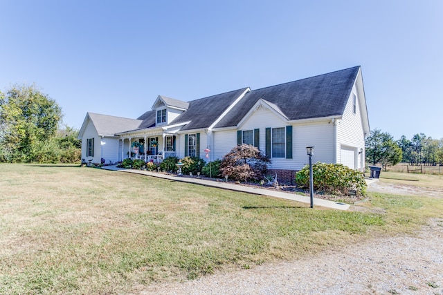 view of front of property featuring a front yard, a garage, and a porch