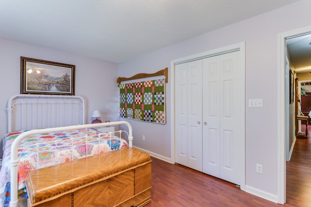 bedroom with dark wood-type flooring, a closet, and a textured ceiling