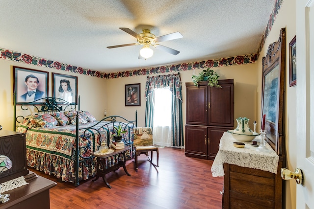 bedroom featuring a textured ceiling, dark hardwood / wood-style floors, and ceiling fan