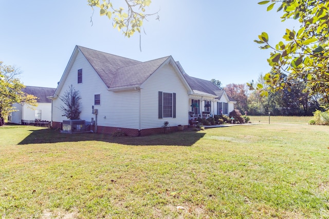 view of side of property featuring a yard and cooling unit