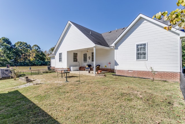 back of house with a patio area and a yard