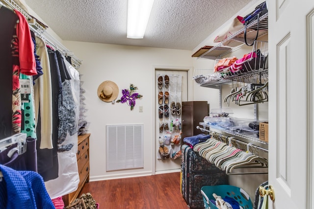 spacious closet with dark wood-type flooring