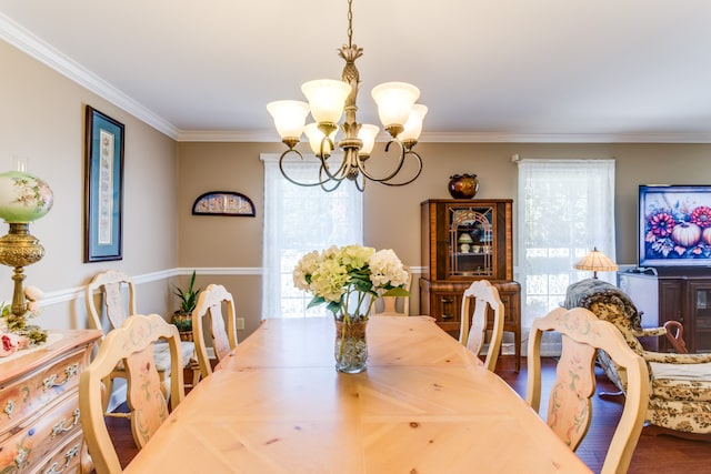 dining area with crown molding, hardwood / wood-style flooring, and a chandelier