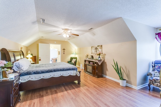 bedroom featuring light hardwood / wood-style flooring, a textured ceiling, lofted ceiling, and ceiling fan