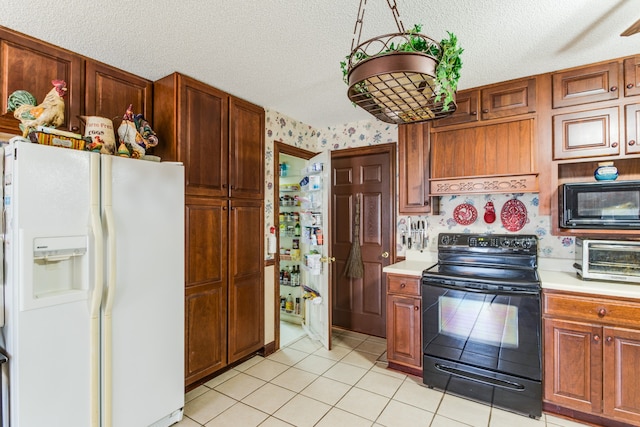 kitchen with light tile patterned flooring, black appliances, and a textured ceiling