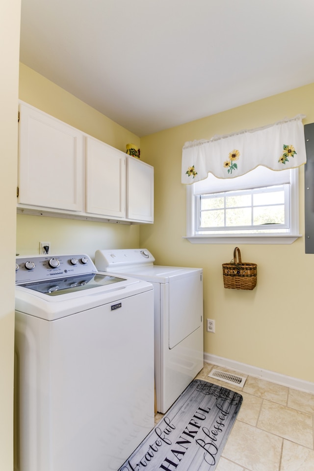 laundry room with independent washer and dryer, light tile patterned floors, and cabinets