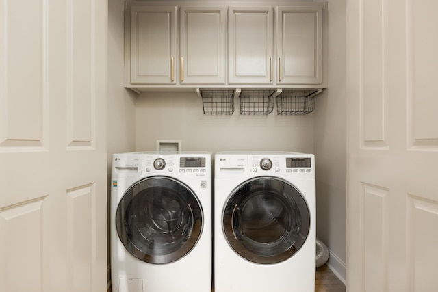 washroom with washing machine and dryer and cabinets