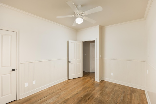 unfurnished room featuring crown molding, wood-type flooring, and ceiling fan