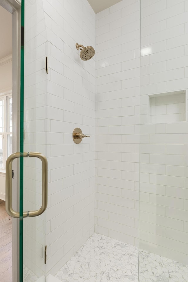 bathroom with crown molding, hardwood / wood-style flooring, and walk in shower